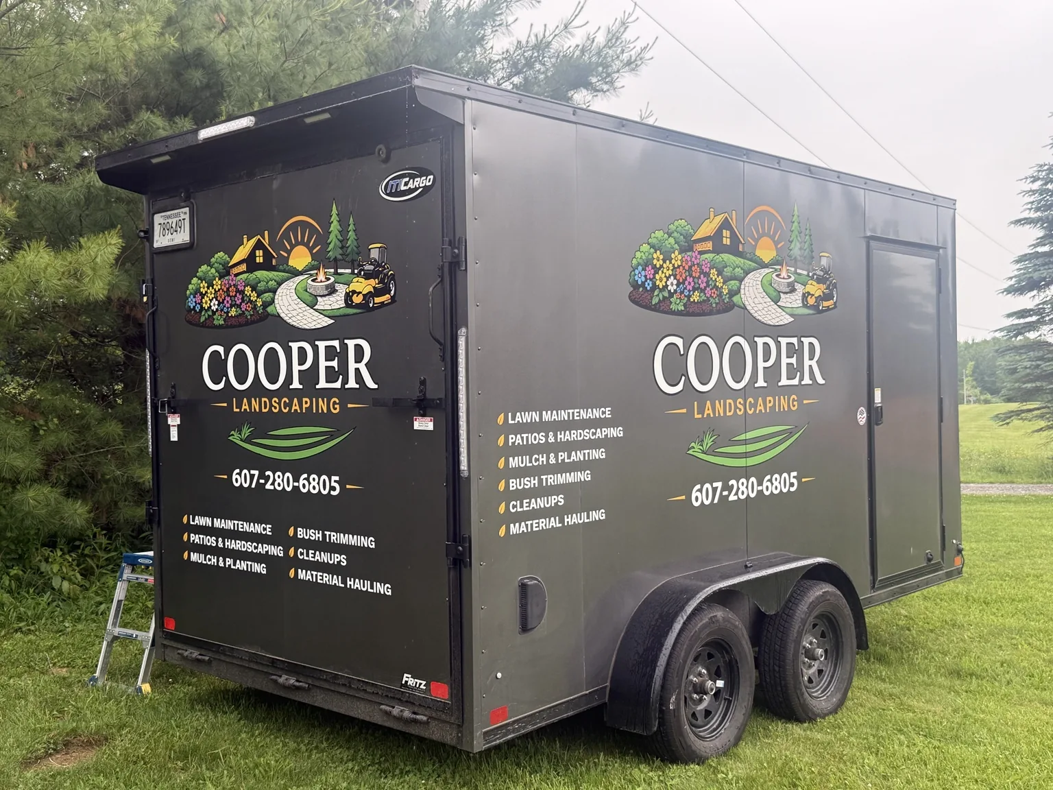 Black enclosed Cooper Landscaping trailer with custom lettering